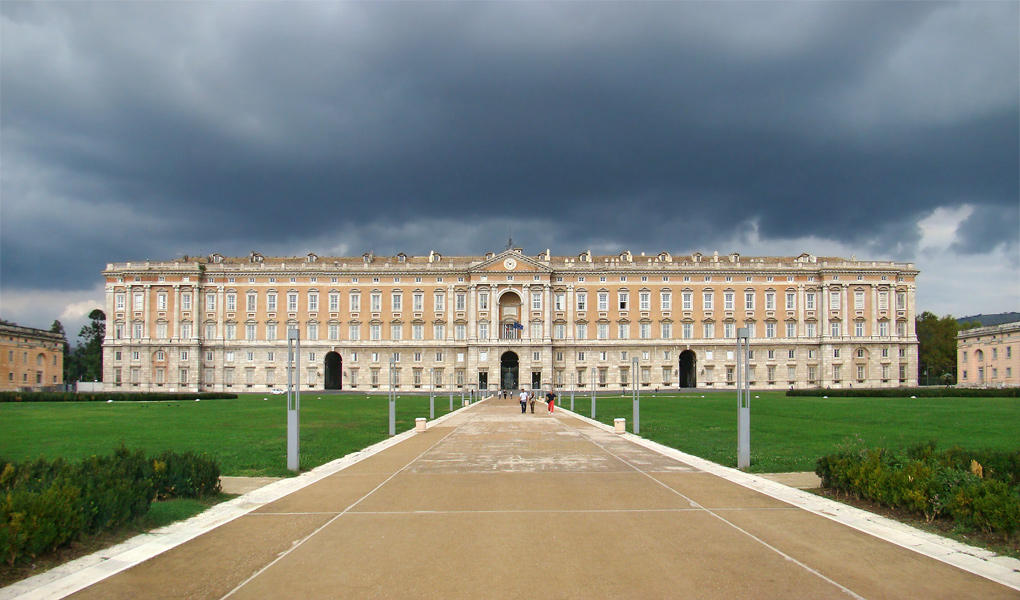 La Reggia di Caserta, progettata dall’architetto Luigi Vanvitelli (1700-1773) e costruita tra il 1752 ed il 1845 per volere di Carlo di Borbone con lo scopo di erigerla quale fulcro del nuovo regno di Napoli. Il fronte del Palazzo e la veduta del giardino reale.