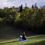 woman in blue dress sitting on green grass field during daytime