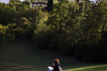 woman in blue dress sitting on green grass field during daytime